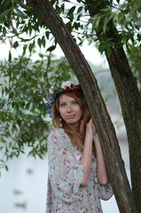 
A girl with long hair in a wreath of flowers and a summer dress
