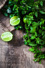 Fresh mint leaves herb and lime  on dark wooden  table. Top view with copy space