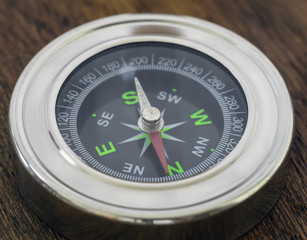 Compass close up shot on wood tabletop. Selective focus.
