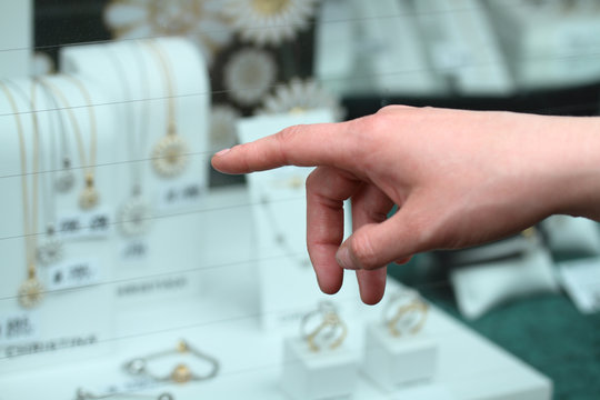 Womans hand pointing at jewellery