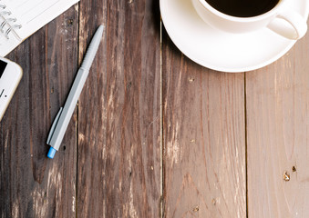 Wood Table background with Hot coffee and notebook. Top view.