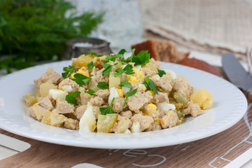 Salad with pollock liver, eggs, potatoes and cucumber, selective focus