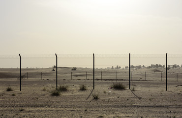 Fence in The Sand Desert at Sunny Day