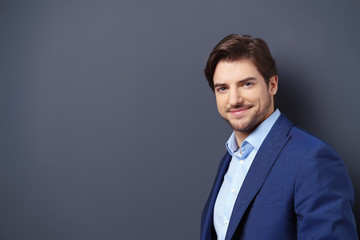 lächelnder geschäftsmann vor grauer wand