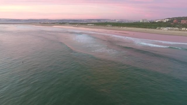 Aerial videoin motion during sunset in the Atlantic Ocean in Costa da Caparica, Lisbon, Portugal.