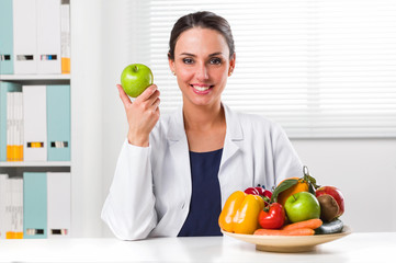 Female nutritionist holding a green apple - 144942851