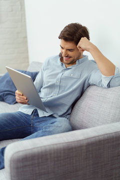 mann liest zuhause am tablet