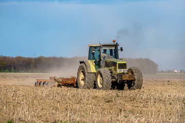 Obraz premium Tractor harrowing the land
