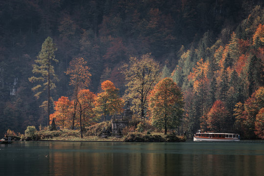 Christlieger Island a statue of John of Nepomuk. Passenger boat on the Koenigssee autumn near Berchtesgaden, Bavaria, Germany