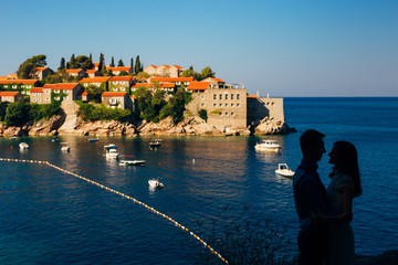 Silhouettes of couples near Sveti Stefan island in Montenegro