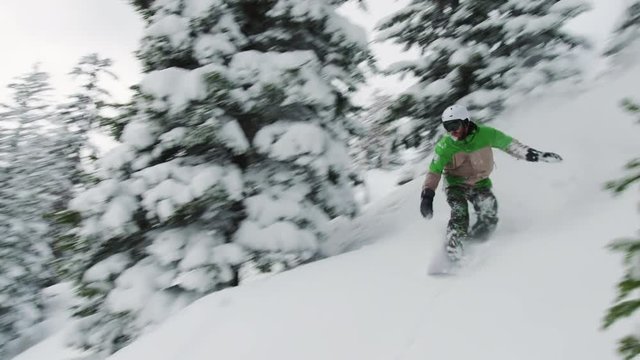 Snowboard Drop Off Pillow Cliff Ridign Through Deep Snow and Trees Green Jacket