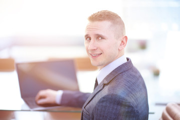 Handsome businessman working with laptop in office