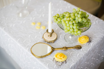 Vase with fruit and a candle on the table