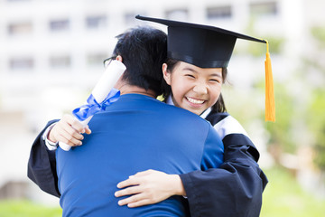 female student and family hug celebrating graduation.