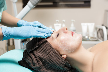 Fototapeta na wymiar anti-aging facial massage. cosmetologist doing massage for young woman at Spa salon.