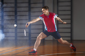 Badminton player beats the shuttlecock in the gym 