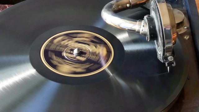 un gramophone en fonctionnement avec son bras de lecture et un disque vinyl