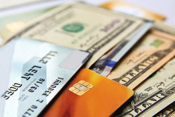 Stack of credit cards and american dollars cash, close-up view.