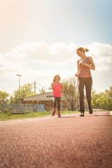 Fototapeta premium Caucasian mother and daughter jogging outdoors.
