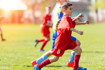 Fototapeta premium Kids soccer football - children players match on soccer field