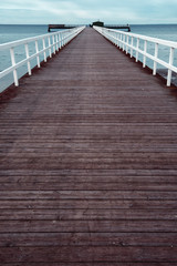 Obraz premium Empty wooden pier walkway on sea shore
