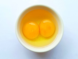 White bowl with eggs on white background.