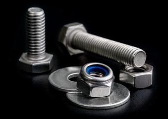screw isolated on the black backgrounds. Nuts with bolts and washers closeup