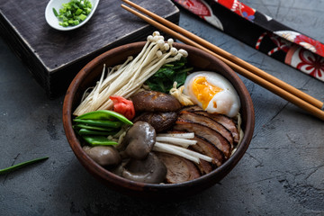 Ramen noodles bowl with egg, enoki, shiitake mushrooms, duck and onion