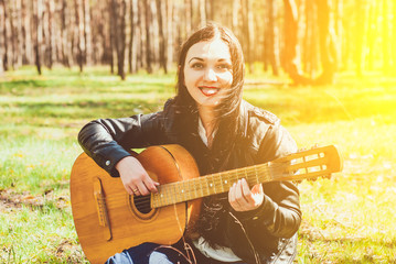 woman playing an acoustic guitar outdoor