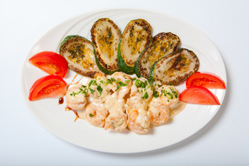 shrimps and grilled zucchini on a white plate