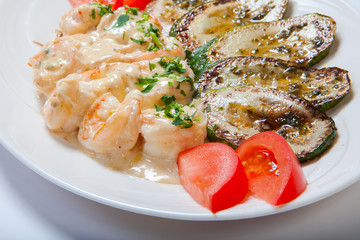 shrimps and grilled zucchini on a white plate