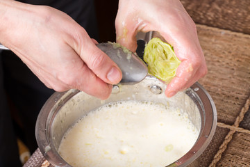 Squeezing lime with metal spoon.