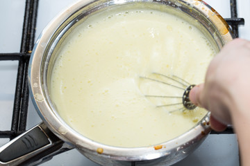 Mixing cake dough in saucepan.