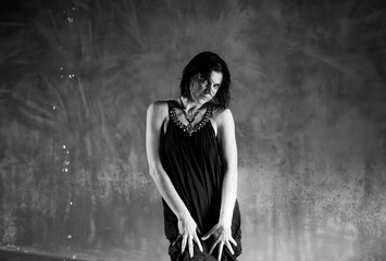 Fototapeta premium Woman with short hair poses in seductive black dress