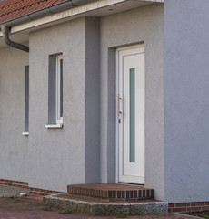 Weiße Haustür mit grauer Fassade