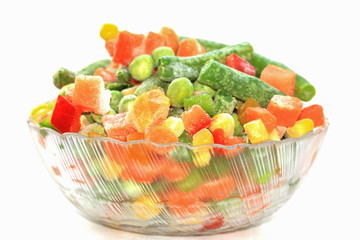 Frozen mixed vegetables in bowl on white background