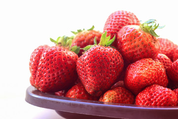 Fresh strawberries in bowl on white background