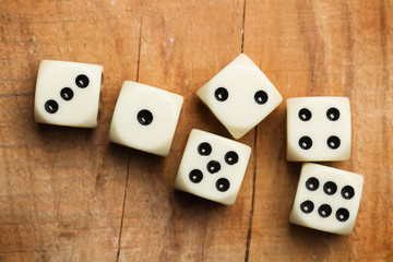 Dados blancos sobre mesa de madera rústica. Vista superior