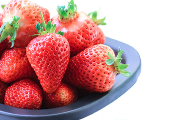 Strawberries in a bowl on white background