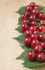 Berry Cherry with leaves on wooden background