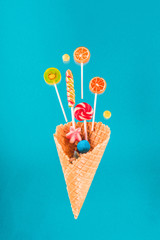Close-up view of crispy waffle cone with sweet candies and lollipops