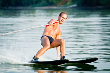 Cheerful mid-adult athlete waterskiing.