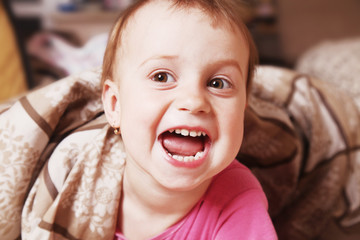 Happy funny baby girl before bedtime (Childhood, laughter, security, joy, reliability concept)