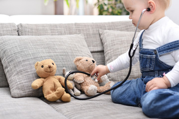 Mädchen untersucht ihre Teddys