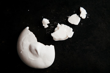 French meringue crumbs on black background with text space