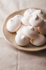 Fototapeta na wymiar Homemade meringues on ceramic plate and linen fabric