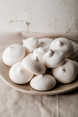 Fototapeta na wymiar Homemade meringues on ceramic plate and linen fabric