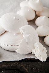 Homemade meringues on ceramic plate and linen fabric