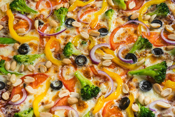 Vegetarian pizza with rosemary and spices on a light wooden background. Italian pizza on a background of green basil and fresh vegetables
