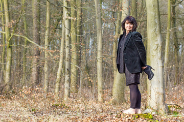 barefoot in the forest / A woman has pulled out her hoes shoes in the forest 
